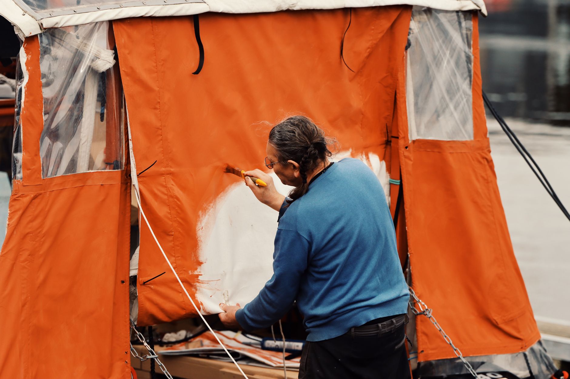 Peintre professionnel appliquant une peinture au pinceau avec précision sur un encadrement extérieur